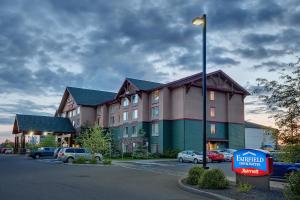 安克雷奇Fairfield Inn & Suites by Marriott Anchorage Midtown的停车场内有车辆的旅馆