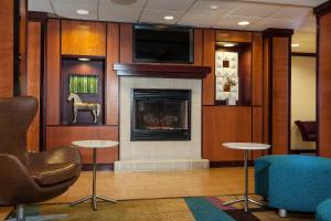安克雷奇Fairfield Inn & Suites by Marriott Anchorage Midtown的大堂设有壁炉、椅子和电视。