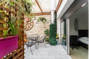 巴黎L'Oasis Montparnasse的庭院配有桌椅和植物