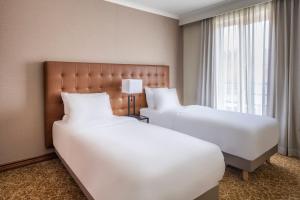 布鲁塞尔布鲁塞尔万豪行政公寓的酒店客房设有两张床和窗户。
