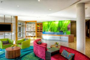 贝灵厄姆万豪贝林翰春季山丘套房酒店的大堂配有色彩缤纷的家具和平面电视。