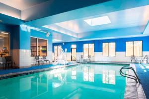 费德勒尔韦Courtyard by Marriott Seattle Federal Way的一个带蓝色墙壁和椅子的大型游泳池