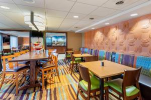 斯卡伯勒Fairfield by Marriott Inn & Suites Portland Maine Airport的用餐室配有木桌和椅子