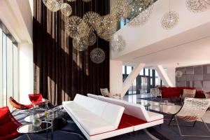 奥兰瓦赫兰艾美酒店的客厅配有白色家具和吊灯。