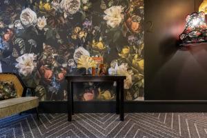 布鲁塞尔布鲁塞尔万丽酒店的墙上一张桌子,墙上挂着花卉图案的壁纸