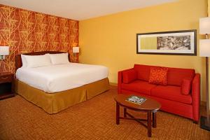 巴尔的摩巴尔的摩市中心/内港万怡酒店的酒店客房,配有一张床和一张红色的沙发