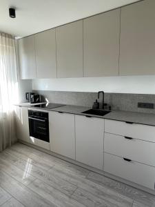 马热伊基艾BALI apartment in central Mažeikiai SELF CHECK-IN 24H的厨房配有白色橱柜和水槽