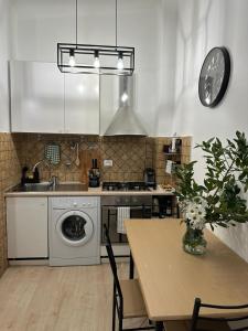 罗马ANNA'S APARTMENT的厨房配有洗衣机和带时钟的桌子。