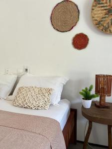 Amontadaicaraizinho villa soleil的一间卧室配有一张带枕头和桌子的床