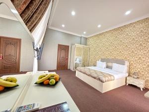巴库Istanbul Gold Hotel的一间卧室配有一张床,桌子上放有水果