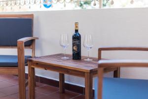 卡拉古诺内Villa Isabel的一张桌子上摆放着一瓶葡萄酒和两杯酒杯