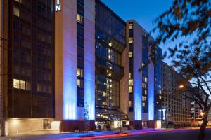 华盛顿华盛顿威斯汀市中心酒店的一座高大的建筑,上面有蓝色的灯光