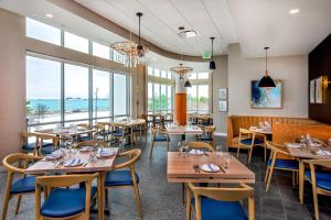 里维尔SpringHill Suites by Marriott Boston Logan Airport Revere Beach的餐厅设有桌椅和窗户。