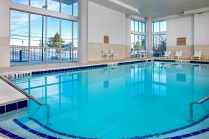 里维尔SpringHill Suites by Marriott Boston Logan Airport Revere Beach的大楼内的一个蓝色海水游泳池