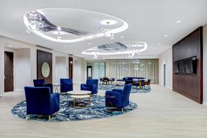 里维尔SpringHill Suites by Marriott Boston Logan Airport Revere Beach的大堂设有蓝色的椅子和桌子。