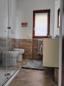 圣佩莱格里诺温泉MANZONI APARTS - SUITE Superior的一间带卫生间、水槽和窗户的浴室