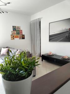圣佩莱格里诺温泉MANZONI APARTS - SUITE Superior的客厅配有沙发和墙上的电视