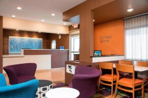 芒特普莱森特普莱森特山费尔菲尔德套房酒店的一间设有紫色椅子和柜台的等候室