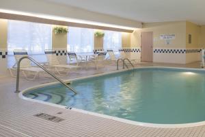 芒特普莱森特普莱森特山费尔菲尔德套房酒店的一个带桌椅的房间的大型游泳池