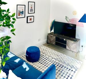 特罗布里奇Cosy One Bedroom Apartment的客厅配有蓝色的沙发和电视