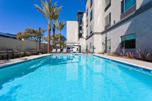 圣地亚哥TownePlace Suites by Marriott San Diego Central的棕榈树建筑前的游泳池