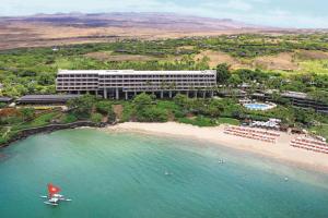 哈普那海滩傲途格精选酒店之冒纳凯阿火山海滩酒店的海滩上的酒店,在水中划船