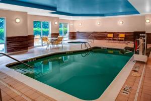 恩波里亚恩波里亚I-95万怡费尔费德酒店及套房的一座配有桌椅的酒店游泳池