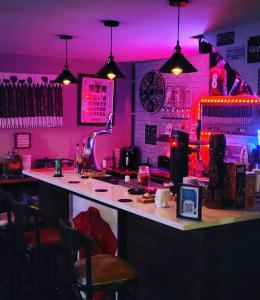 西班牙角Atlantic Coast Lodge的一间酒吧,配有粉红色的灯光和吧台