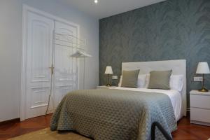 拉科鲁尼亚Céntrico y acogedor piso con garaje的卧室配有白色的床和绿色的墙壁