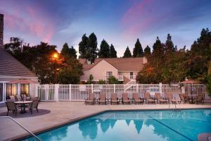 森尼维耳市桑尼维尔硅谷II酒店的一个带桌椅的游泳池和一个围栏