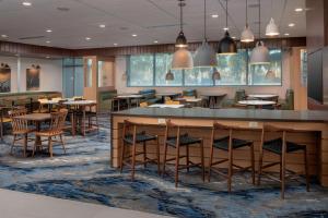 迈阿密Fairfield Inn & Suites by Marriott Miami Airport West/Doral的餐厅的 ⁇ 染,配有桌椅