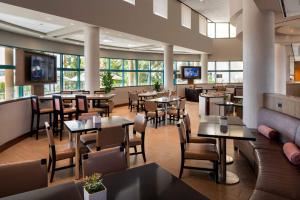 纽波特海滩纽波特海滩万豪湾景酒店的餐厅设有桌椅和窗户。