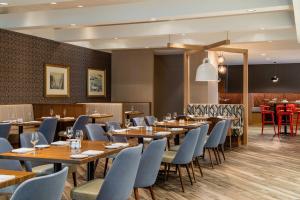圣约翰斯三角洲圣约翰酒店和会议中心的餐厅设有木桌和蓝色椅子