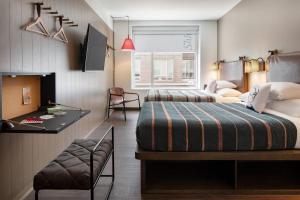 奥斯汀Moxy Austin - University的酒店客房配有两张床和一张书桌