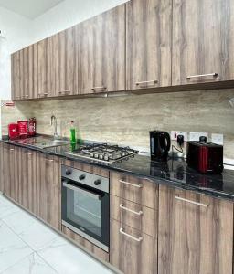 比尔基卡拉The Hazel penthouse with private jacuzzi的厨房配有木制橱柜和炉灶烤箱。