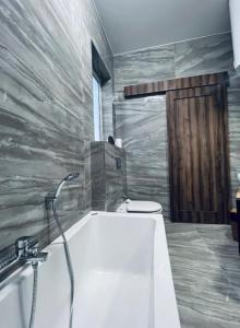 比尔基卡拉The Hazel penthouse with private jacuzzi的带浴缸和卫生间的浴室。