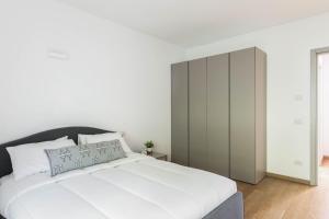 格里安泰卡德纳比亚Casa Divina - Cadenabbia的卧室配有白色的床和橱柜。