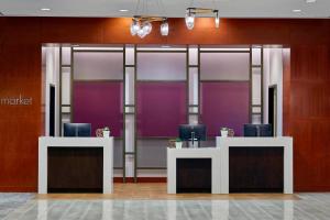 波特兰波特兰市中心/会议中心万怡酒店的大堂设有紫色墙壁和带椅子的书桌