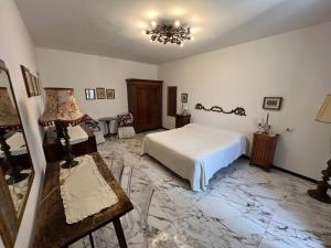 萨杜勒尼亚Le Camere dei Magi的一间卧室配有一张床、一张桌子和一盏灯