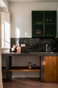 贝赫尔-德拉弗龙特拉Casa Uva - Boutique Guest House的厨房配有绿色橱柜和木板凳