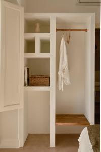 贝赫尔-德拉弗龙特拉Casa Uva - Boutique Guest House的卧室设有白色墙壁和带架子的衣柜。