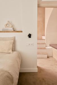 贝赫尔-德拉弗龙特拉Casa Uva - Boutique Guest House的卧室拥有白色的墙壁和一张床,设有楼梯