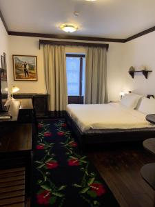 培拉特曼加勒米酒店的配有一张床和一张书桌的酒店客房