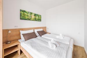 弗林布尔克Deluxe Apartment Lipno - Lake Side Village, Frymburk nad Vltavou的一间卧室配有两张带白色床单的床