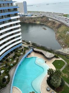 伊斯坦布尔Ottomare Suites sea, view, pool, gym的一座大型建筑,设有游泳池,毗邻海滩