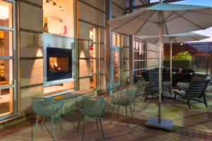 塔拉哈西塔拉哈西市中心雅乐轩酒店的一个带椅子和遮阳伞的庭院和一个壁炉