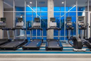 萨凡纳Aloft Savannah Airport的健身房设有数台跑步机和大窗户