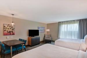 巴拿马城海滩TownePlace Suites by Marriott Panama City Beach Pier Park的酒店客房设有两张床、一张桌子和一台电视。