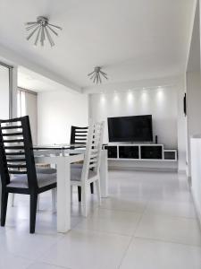 佛罗里达布兰卡Apartamento Lux Confort的一间带桌椅和电视的用餐室