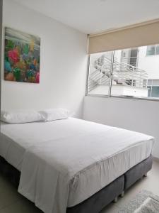 佛罗里达布兰卡Apartamento Lux Confort的白色的卧室设有一张大床和一个窗户